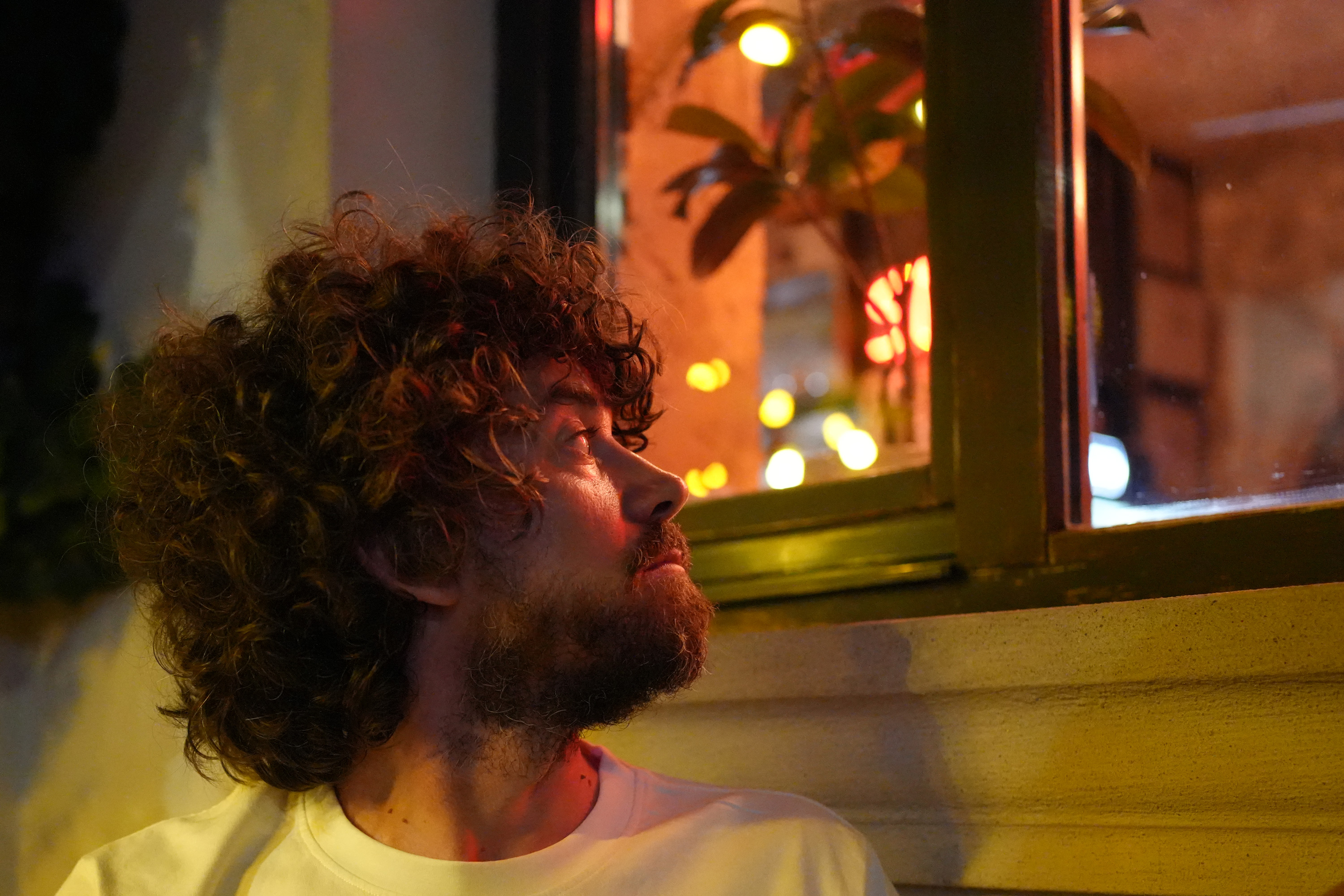 Portret de noapte la lumina geamului - privire curioasă spre lumină