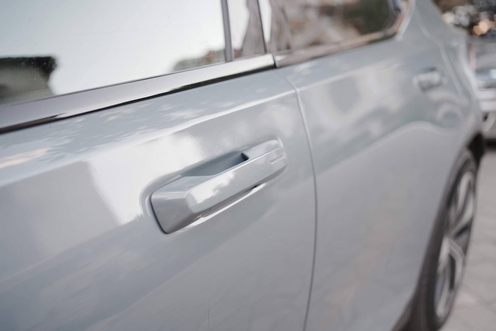 The front door's exterior handle, in plain sight, in body colour, with the locking recess at its end