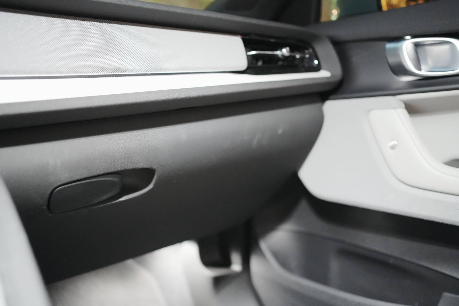The glovebox in front of the passenger seat, with its mechanical release handle; above, the air vent with its metal knob